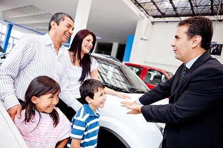 Car salesman showing a family of 4 a car